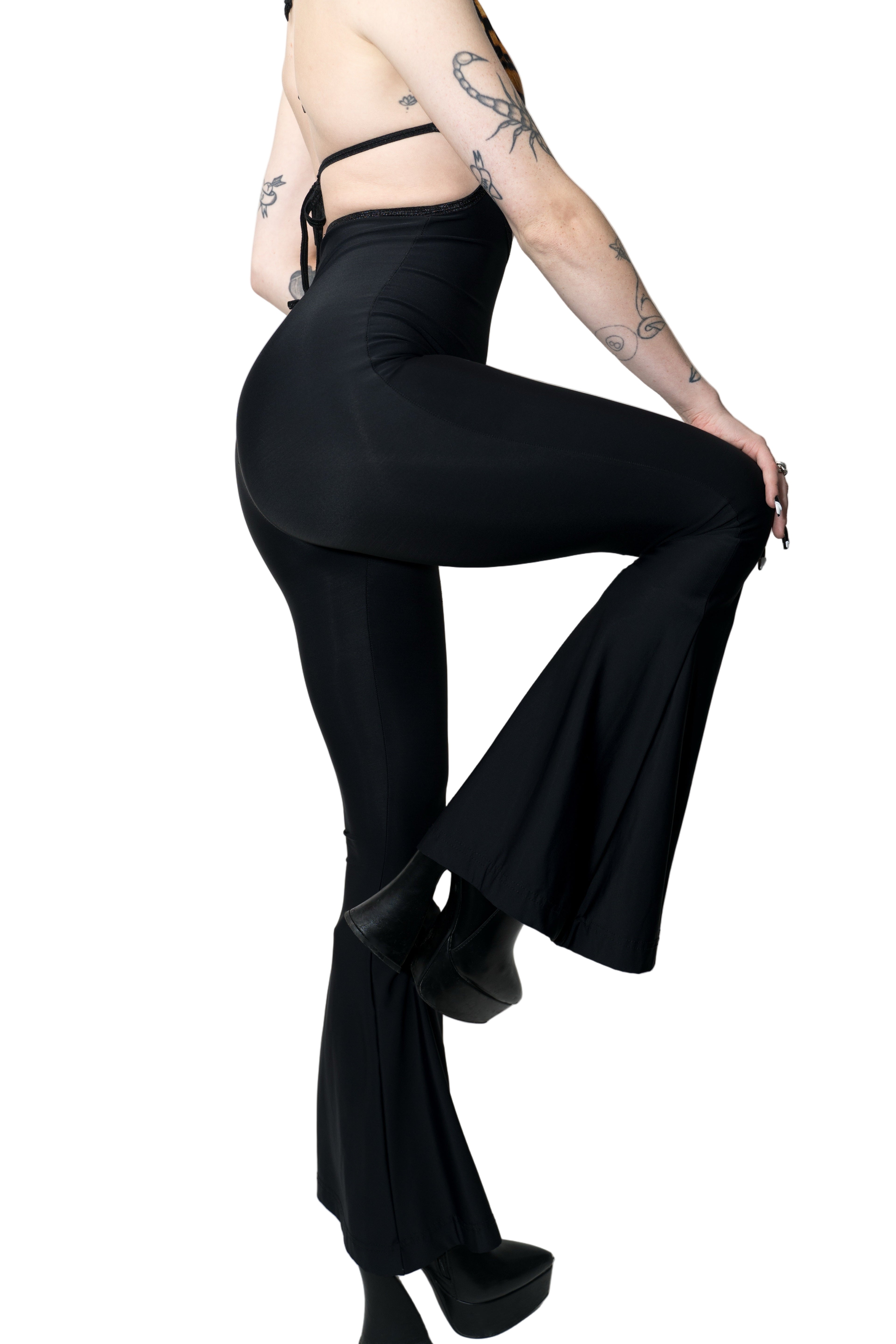Person wearing black high-waisted pants on a white background